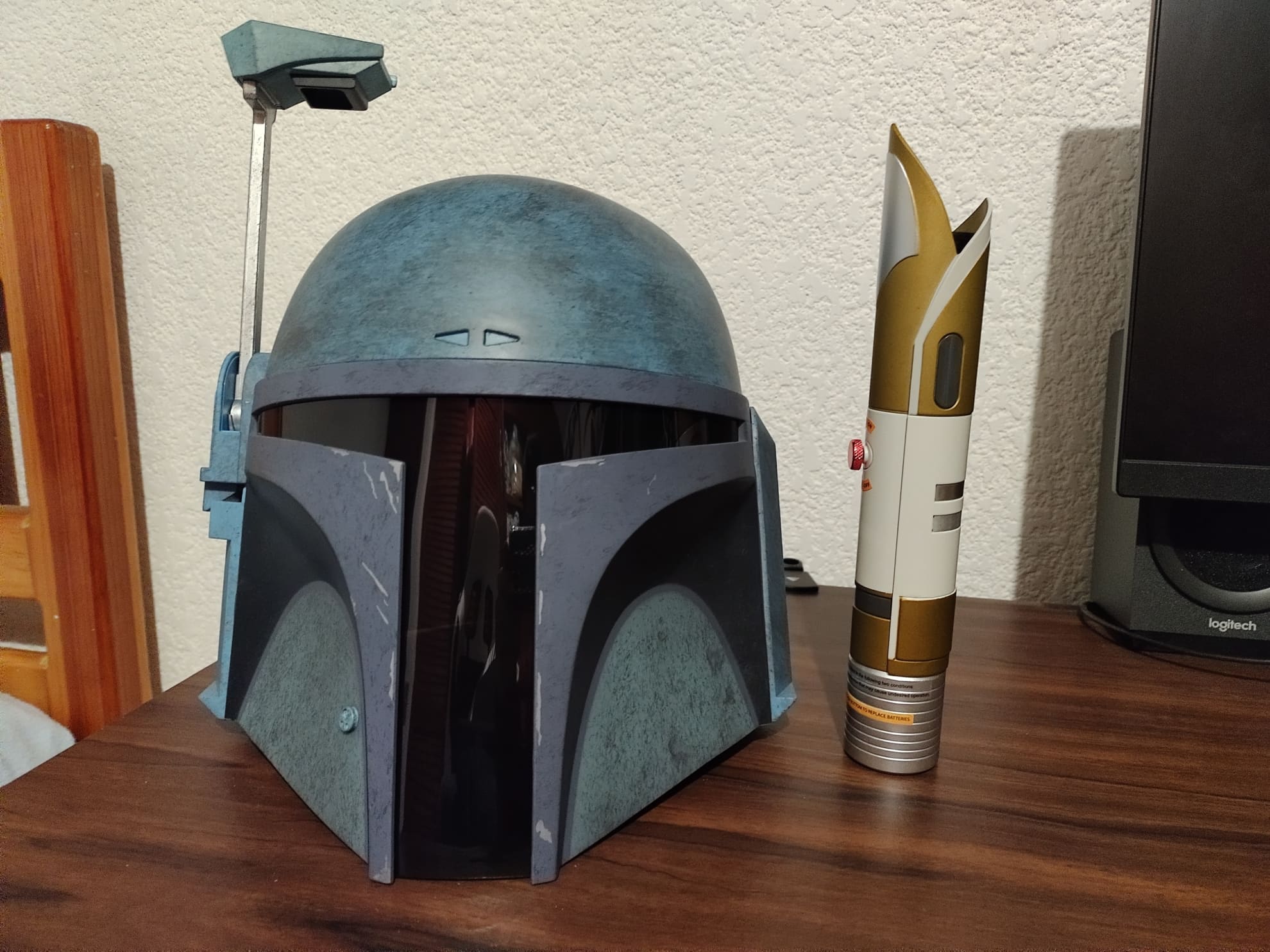 Black Series Star Wars Death Watch Mandalorian Helmet review - next to a lightsaber hilt